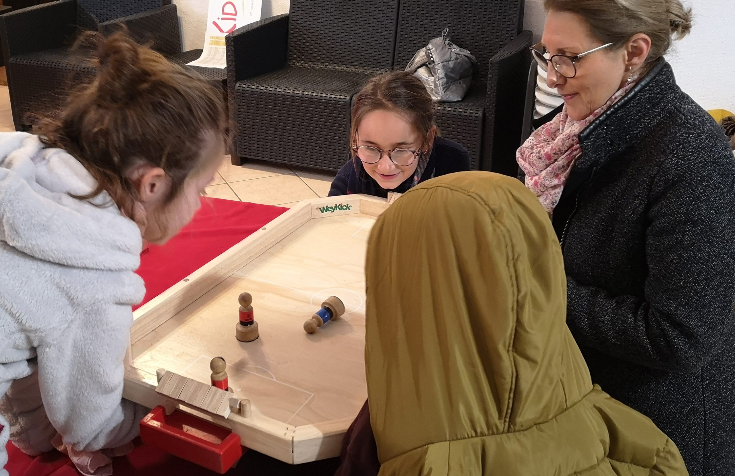 Enfants et adulte réunis autour d’un jeu au Kidcat